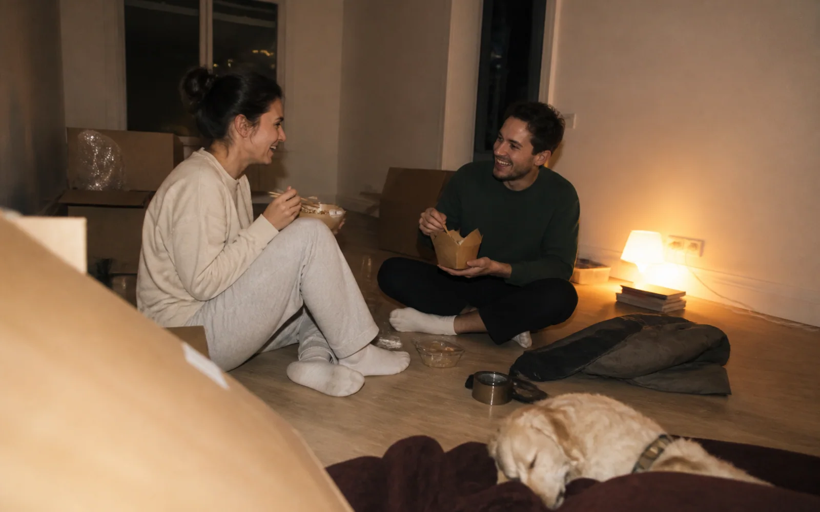 Friends share dinner on the floor of a new home after moving day