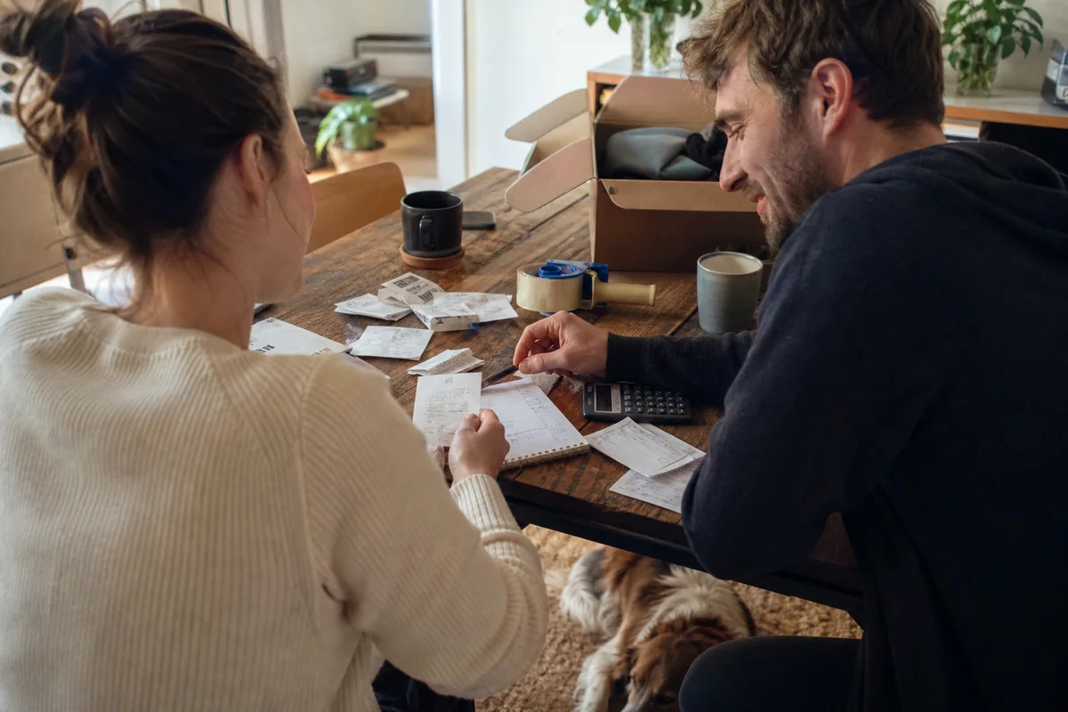 A couple reviews their moving costs at the kitchen table